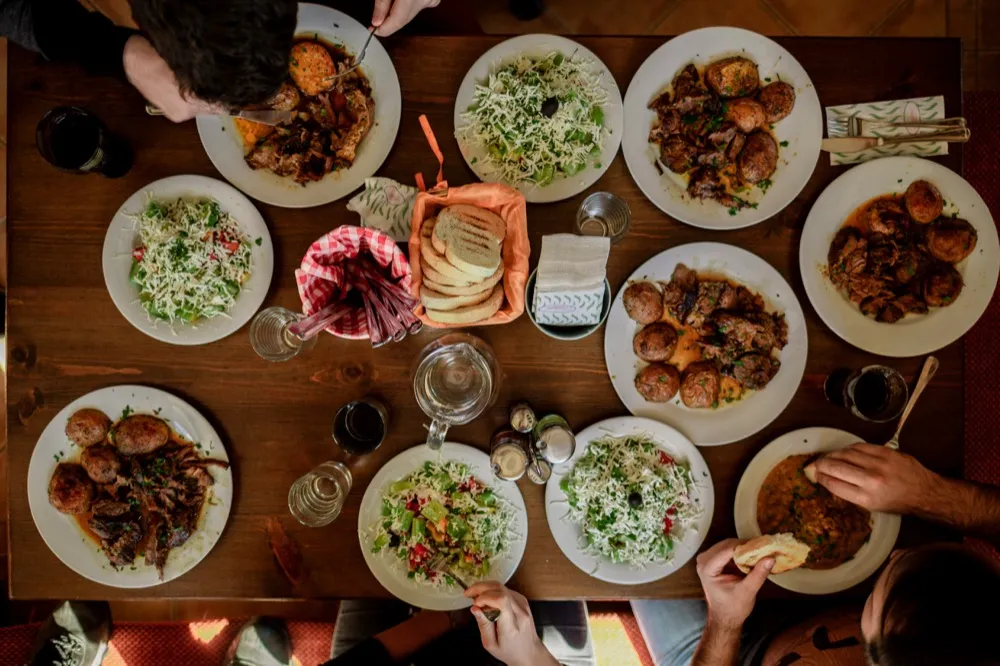Overhead view of dinner table with hands reaching